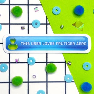 May include: A sticker with the text "THIS USER LOVES FRUTIGER AERO" in white on a blue background, with a user icon. The sticker is surrounded by blue circles, green pom-poms, and iridescent beads, set against a white grid and green background.