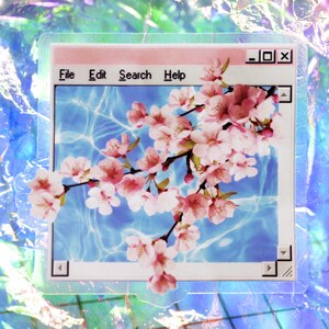 A see threw shot of the vaporwave aesthetic sticker of a pink web window and a pink Japanese cherry blossom extending beyond the frame.