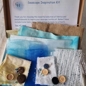Puede incluir: Un kit de inspiración para paisajes marinos con una variedad de telas, botones y cuentas. El kit incluye una nota que dice "Seascape Inspiration Kit" y "Gracias por elegir esta hermosa selección de telas y adornos para inspirar tu arte textil de paisajes marinos. A continuación, he incluido algunas instrucciones básicas sobre cómo creo mis obras de arte. Necesitarás..."