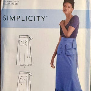 May include: Simplicity sewing pattern S9049 for a wrap skirt with pockets and a ruffle hem. The pattern includes sizes US 14-22. The image shows a woman wearing a blue wrap skirt. The text "EASY-TO-SEW" and the Simplicity logo are visible.