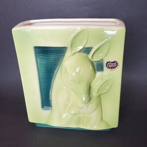 May include: A green ceramic planter with a raised design of a kangaroo and her joey. The planter has a blue and green striped background and a Royal Copley label.