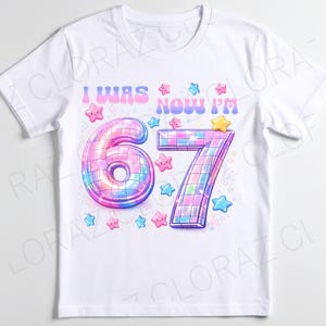 Pu&ograve; includere: T-shirt bianca con un design grafico colorato. Il design presenta il testo "I WAS NOW I'M" sopra il grande numero "67" in stile discoteca, circondato da stelle rosa, blu e gialle.
