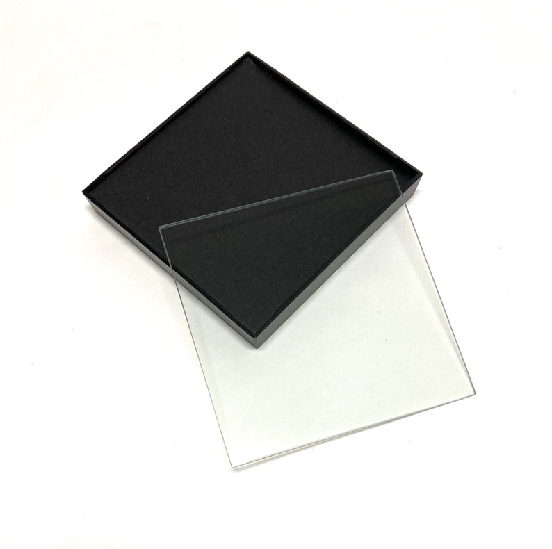 May include: A black ink pad with a clear plastic lid. The lid is slightly ajar, revealing the black ink pad inside.