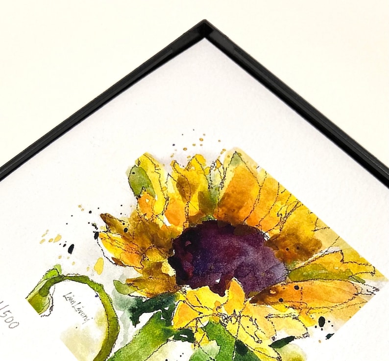 May include: A watercolor painting of a sunflower with yellow petals and a dark purple center. The painting is framed in a black frame and has the artist's signature "Lisa Livoni" and the number "1500" in the bottom left corner.
