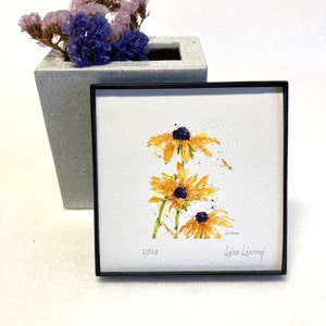 May include: A framed watercolor painting of three yellow flowers with black centers. The painting is signed "Lisa Livony" and numbered "2/500".