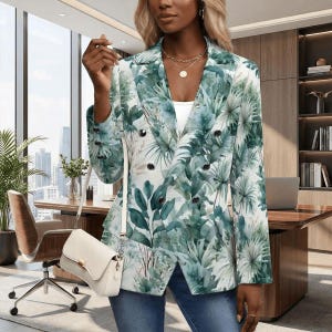May include: Double-breasted blazer with a botanical print in shades of green and white. The jacket has a notched lapel and black buttons. A white purse with a gold-tone chain strap is visible.