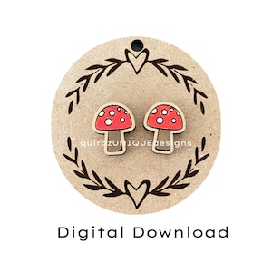 Peut inclure: Une paire de boucles d'oreilles en bois en forme de champignon avec des dessus rouges et des pois blancs. Les boucles d'oreilles sont présentées sur une étiquette ronde en bois avec un cœur et un motif floral. L'étiquette porte également le texte "Téléchargement numérique".