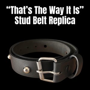 Puede incluir: Una taza de cerámica blanca con un asa negra y el texto "But First, Coffee" en negro, con una fuente de estilo manuscrito. La taza está sobre una superficie blanca.