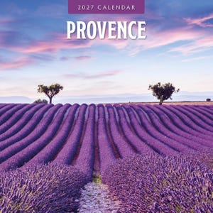 May include: A 2027 calendar featuring a landscape photograph of rows of purple lavender fields in Provence under a soft pink and blue sunset sky. The text 2027 CALENDAR is printed in white at the top, followed by the word PROVENCE in large white letters.