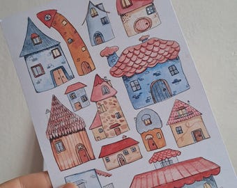 Op de afbeelding: Waterverfillustratie van grillige huizen in verschillende vormen en kleuren. De huizen hebben rode, blauwe, oranje en bruine daken, met unieke architectonische details zoals gewelfde deuren en puntige torens. Het kunstwerk staat op een witte achtergrond.
