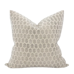 Peut inclure: Un coussin de décoration de couleur crème avec un motif floral noir et blanc.