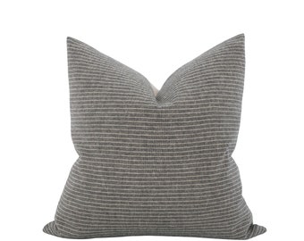 May include: A grey and white striped throw pillow with a subtle texture. The pillow is made of a soft, comfortable fabric and is perfect for adding a touch of style to any room.