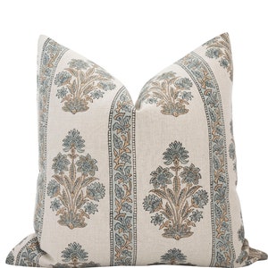 May include: A decorative throw pillow with a white linen fabric and a blue and brown floral pattern.