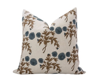 May include: A white pillow with a blue and brown floral pattern. The pillow is made of a soft, linen fabric.
