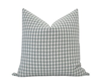 May include: A soft, light blue and white gingham pillow cover. The pillow cover is made of a woven fabric with a subtle texture.