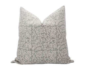 May include: A gray and white patterned throw pillow with a floral design.