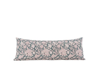 May include: A long, rectangular pillow with a teal background and a pink floral pattern.