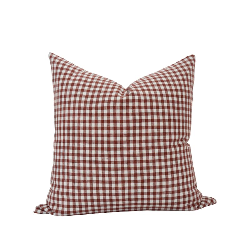 May include: A red and white gingham pillow with a square pattern. The pillow is made of a soft, woven fabric.