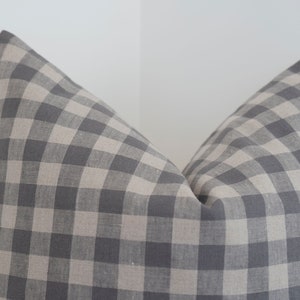 May include: A gray and white gingham pillow cover. The pillow cover is made of a soft, woven fabric.