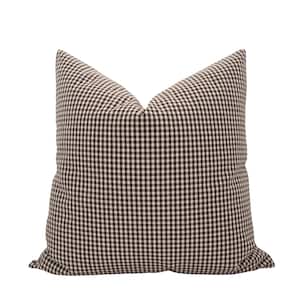 May include: A square cushion featuring a brown and white gingham check pattern. The cushion is designed for home decor and has a soft, textured appearance. The neutral colour scheme makes it suitable for various interior styles.