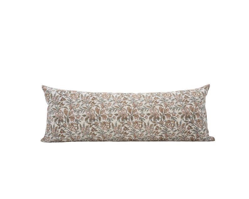Peut inclure: Un long coussin rectangulaire d&eacute;coratif avec un motif floral. Le coussin pr&eacute;sente un fond cr&egrave;me avec un motif r&eacute;p&eacute;t&eacute; de fleurs et de feuilles marron, vertes et grises. Le coussin est con&ccedil;u pour une utilisation d&eacute;corative sur un lit ou un canap&eacute;.