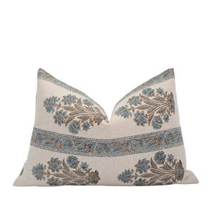 Könnte beinhalten: Ein rechteckiges Zierkissen mit floralem Muster. Das Kissen hat einen cremefarbenen Hintergrund mit blauen und braunen floralen Designs. Das Design beinhaltet einen Rand mit einem sich wiederholenden floralen Muster.