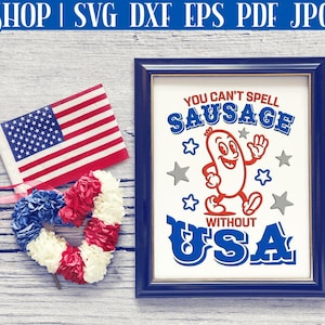 Pode incluir: Uma placa emoldurada em azul com o texto "You can't spell sausage without USA" em vermelho, branco e azul. Uma salsicha de desenho animado com um rosto sorridente e bra&ccedil;os est&aacute; andando. A placa est&aacute; em um fundo de madeira com uma coroa em forma de cora&ccedil;&atilde;o vermelho, branco e azul e uma bandeira americana.
