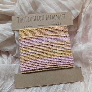 May include: A roll of pink and yellow twine with the text "The Hedgerow Alchemist" on a brown label.