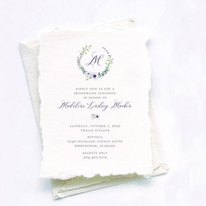 May include: A white invitation with a floral wreath and the letter "M" in the center. The text reads "Kindly join us for a bridesmaids luncheon in honor of Madeline Lording Macker, Saturday, October 1, 2022, Twelve o'clock, Bottega, 2240 Highland Avenue South, Birmingham, Alabama, Regrets Only, 404.405.6116."