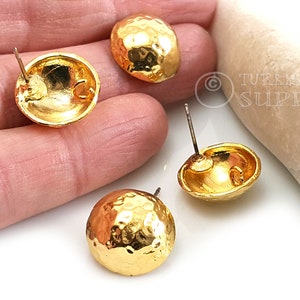May include: Three gold-toned hammered metal stud earrings with post backs. The earrings are round and have a textured surface.