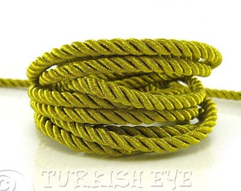 May include: A close-up of a spool of yellow twisted cord. The cord is made of a soft, silky material and is perfect for crafting projects.