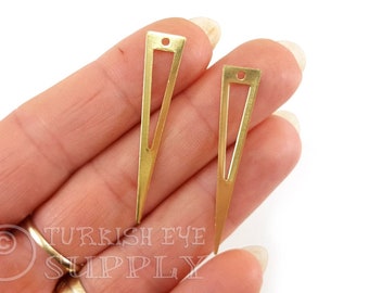 May include: Two gold-colored metal triangle pendant charms with a small hole at the top. The charms are open on one side and have a pointed tip.