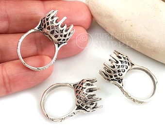 Puede incluir: Tres engastes de anillo de plata con un diseño calado decorativo. Los engastes están diseñados para sujetar una piedra cabujón.