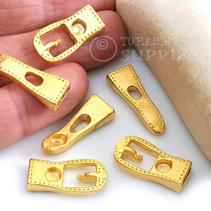 Puede incluir: Seis hebillas de metal dorado con un patrón de puntos decorativos. Las hebillas son de varias formas y tamaños, incluyendo rectangulares y ovaladas.