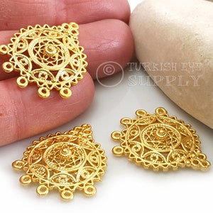 May include: Three gold-coloured metal pendants with intricate filigree designs. Each pendant features a circular centre with a smaller circle in the middle. The pendants have five loops at the bottom.