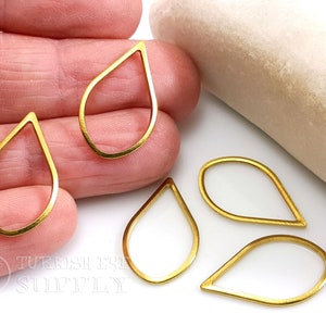 Op de afbeelding: Vijf gouden traanvormige metalen frames, perfect voor het maken van sieraden of knutselprojecten.