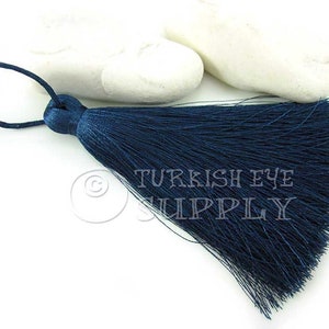 May include: A dark blue tassel with a loop at the top. The tassel is made of soft, silky threads and is approximately 5 cm long.