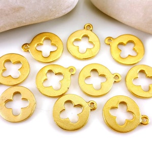 May include: Ten gold-colored metal charms with a flower cutout design. Each charm has a loop for attaching to jewelry or other crafts.