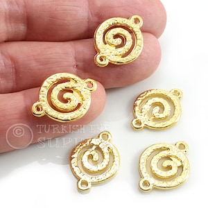 May include: Several gold-colored spiral-shaped jewelry findings with textured surfaces. Each finding has three small holes for attaching to other components. The findings are displayed against a white background.