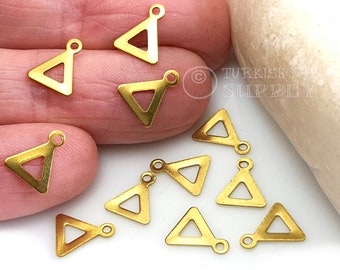 May include: Ten gold-toned triangle shaped metal charms with a loop at the top.  The charms are scattered on a white surface.
