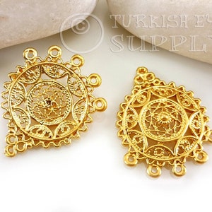 May include: Two gold filigree metal charms with a circular design and multiple loops. The charms are in the shape of a diamond.