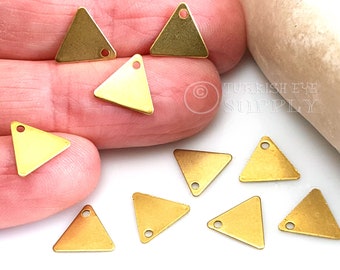 May include: Ten gold triangle charms with a hole at the top. The charms are about 1 inch in size.