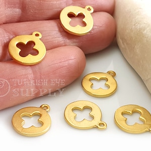 May include: Six gold-toned metal charms with a four-leaf clover design. Each charm has a loop for attaching to a necklace or bracelet.