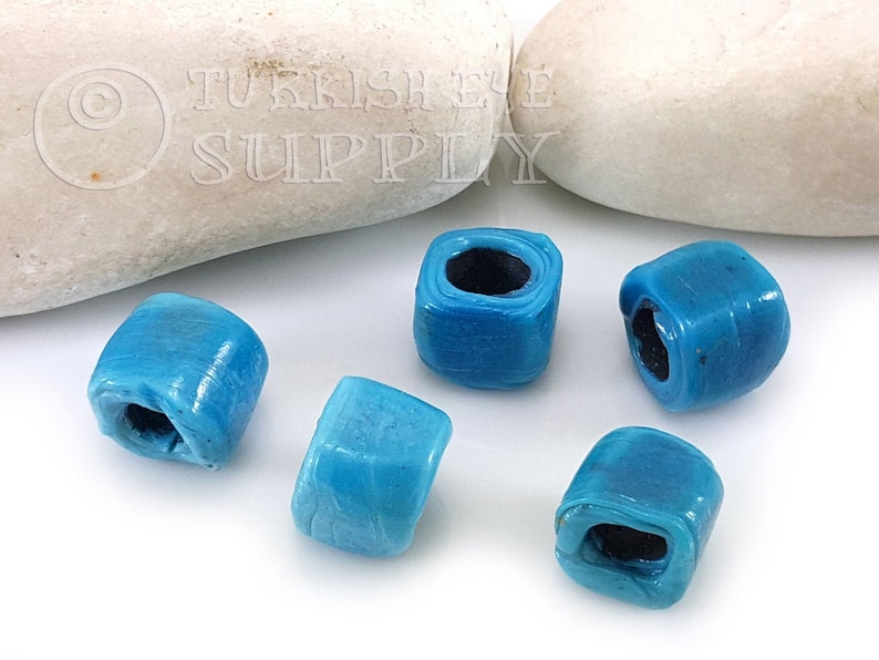 Peut inclure: Six perles carr&eacute;es en verre bleu turquoise avec un trou au centre. Les perles mesurent environ 1,2 cm de diam&egrave;tre.