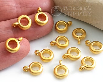 May include: Gold-toned metal jump rings with a loop on top. The jump rings are approximately 1 inch in diameter.