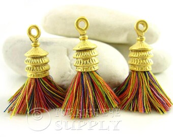 May include: Three gold tassel toppers with a multi-colored tassel. The toppers are shaped like a pagoda with three tiers.