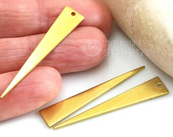 May include: Three gold-colored metal triangle shapes with a hole at the top. The triangle shapes are pointed at the bottom and have a matte finish.
