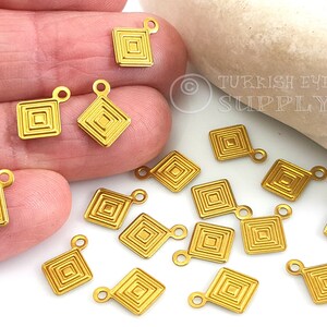 May include: Gold-toned metal charms with a geometric square design. Each charm has a loop for attaching to jewellery or other crafts.