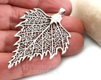 Op de afbeelding: Zilveren filigraan blad hanger met een delicaat, ingewikkeld ontwerp. De hanger is bladvormig met een gedetailleerd aderspatroon. Het is een prachtig en uniek sieraad.