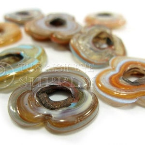 May include: Assortment of colorful glass flower-shaped beads with a hole in the center. The beads have a layered, swirled pattern in shades of brown, blue, and white.